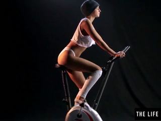 Liebenswert verschwitzt teenager aneinander reiben ein exercise bike sitz.